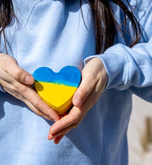 Close-up, heart in the color of the flag of Ukraine in female hands, the concept of peace in Ukraine, no war.